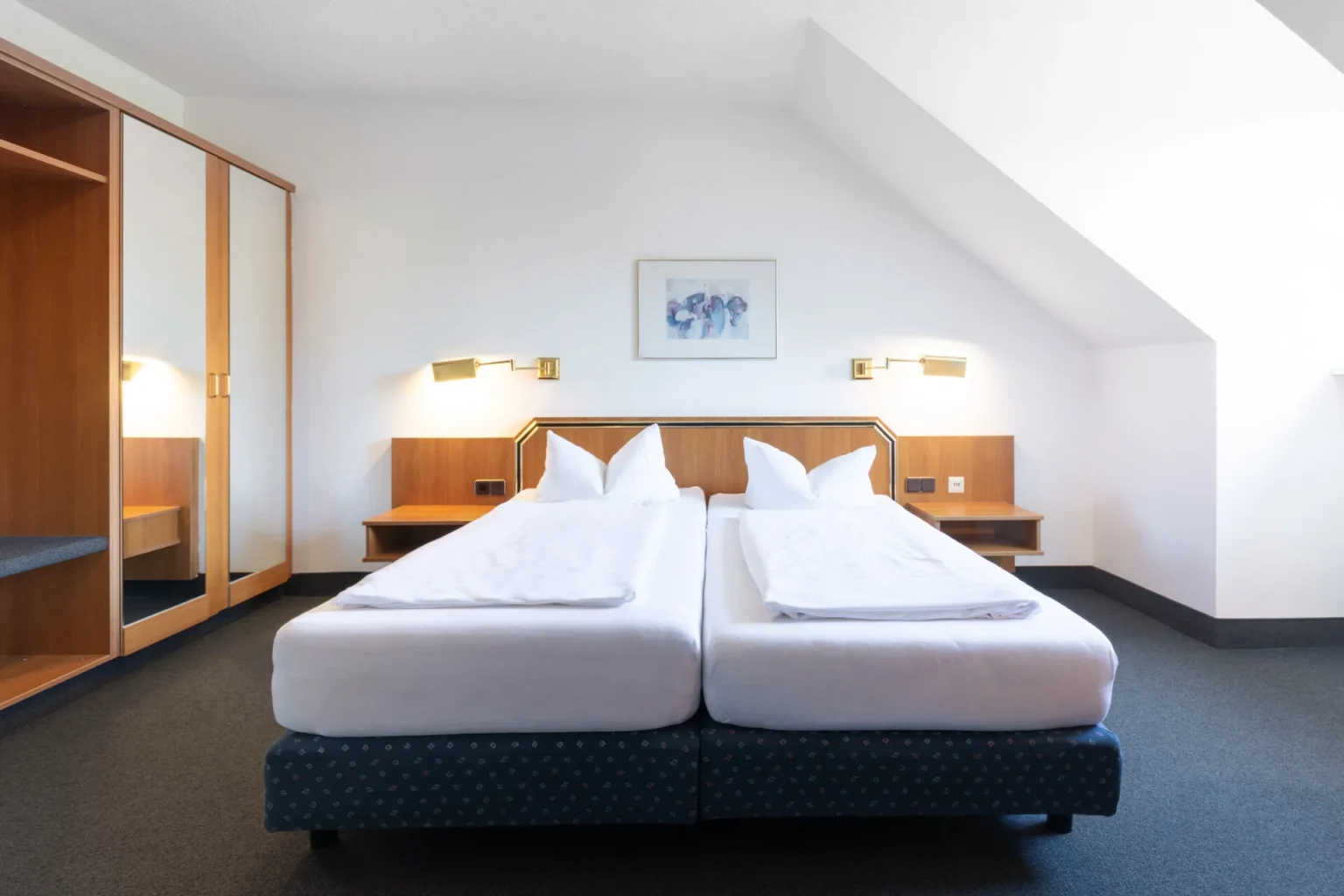 Doppelzimmer mit großem Doppelbett und Kommode